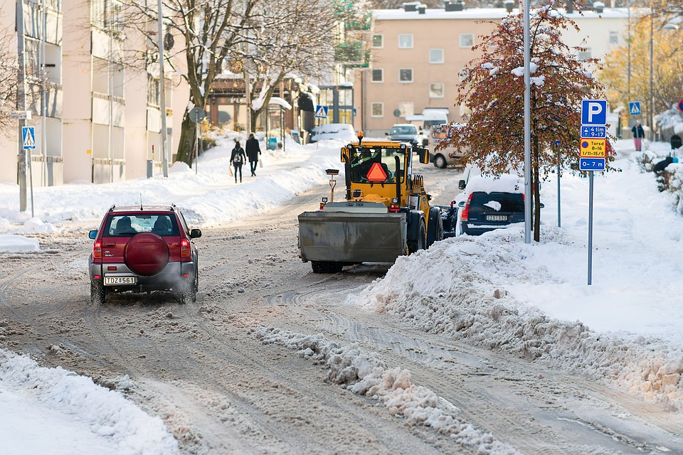 Cars and a plow on a snowy road