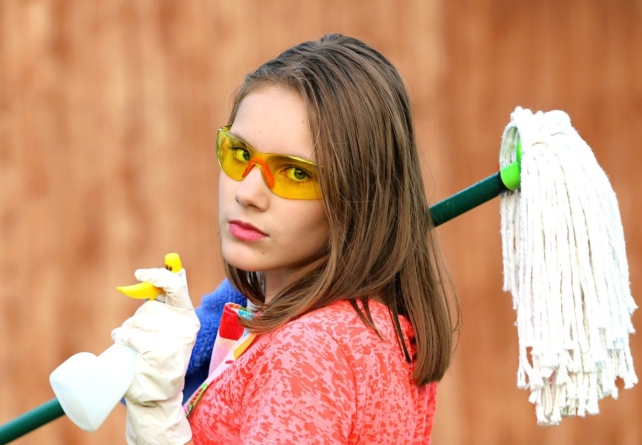 A woman holding a mop over her shoulder