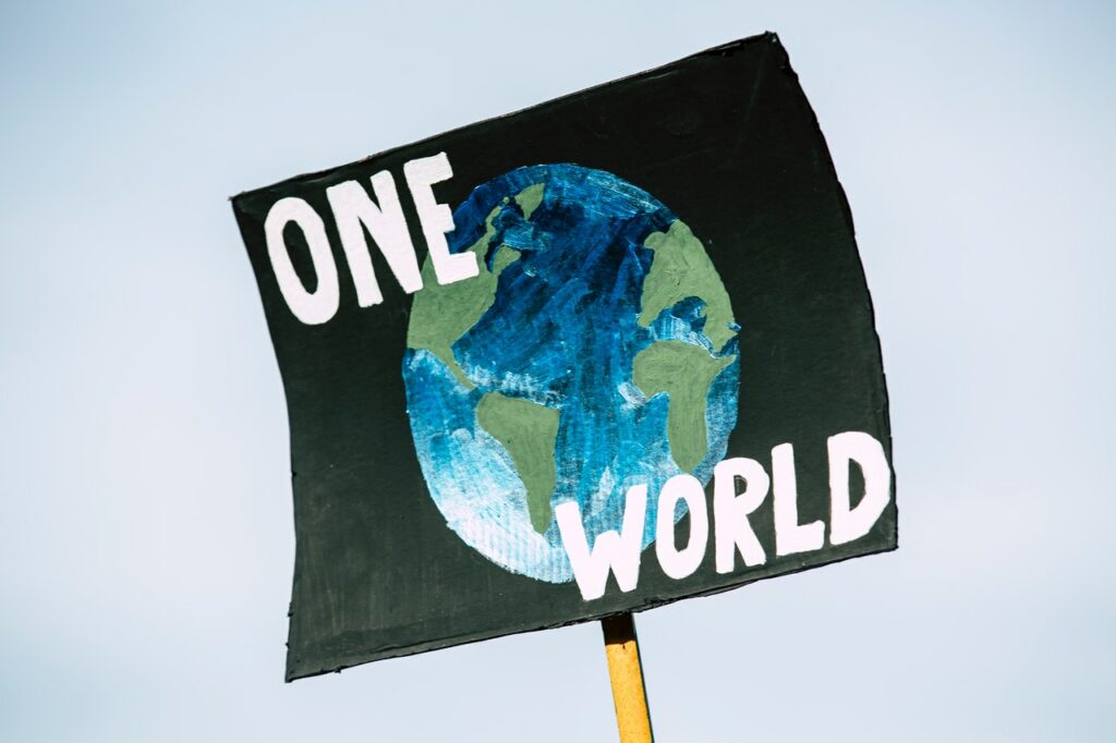 Sign that says "One World" with the planet Earth depicted on it