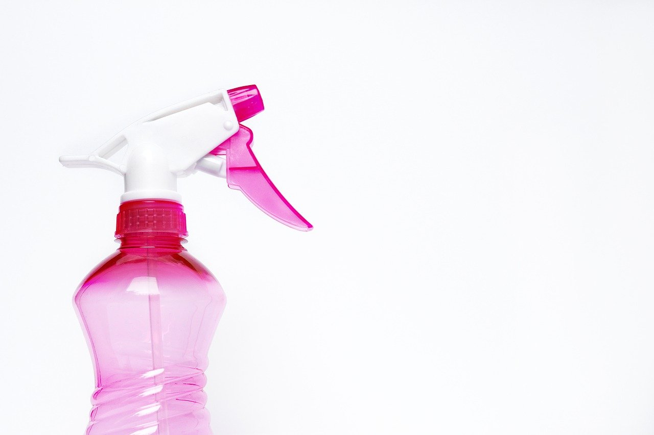 Pink spray bottle on white background