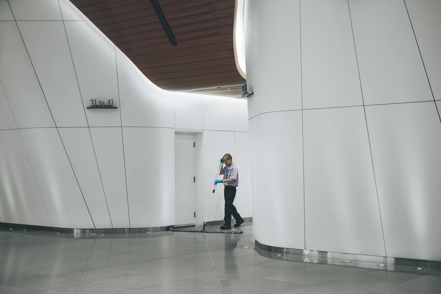 Person using a wide mop to mop a hallway