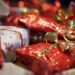 Gifts wrapped and stacked beneath a tree in gold and red.