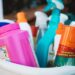 A close up of a plastic tub full of cleaning supplies