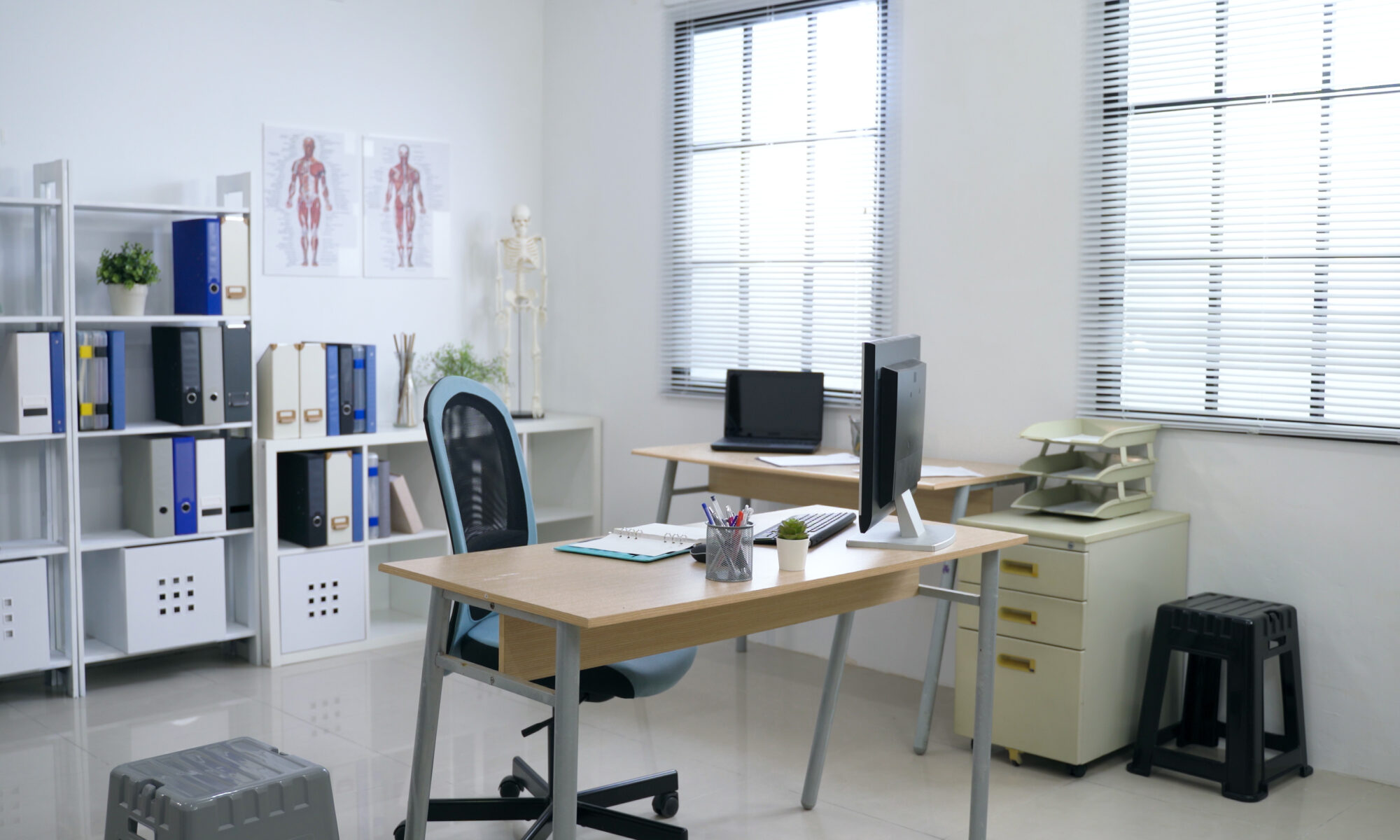 panoramic view of clean and white hospital office with sufficient natural light through louver windows.