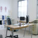 panoramic view of clean and white hospital office with sufficient natural light through louver windows.