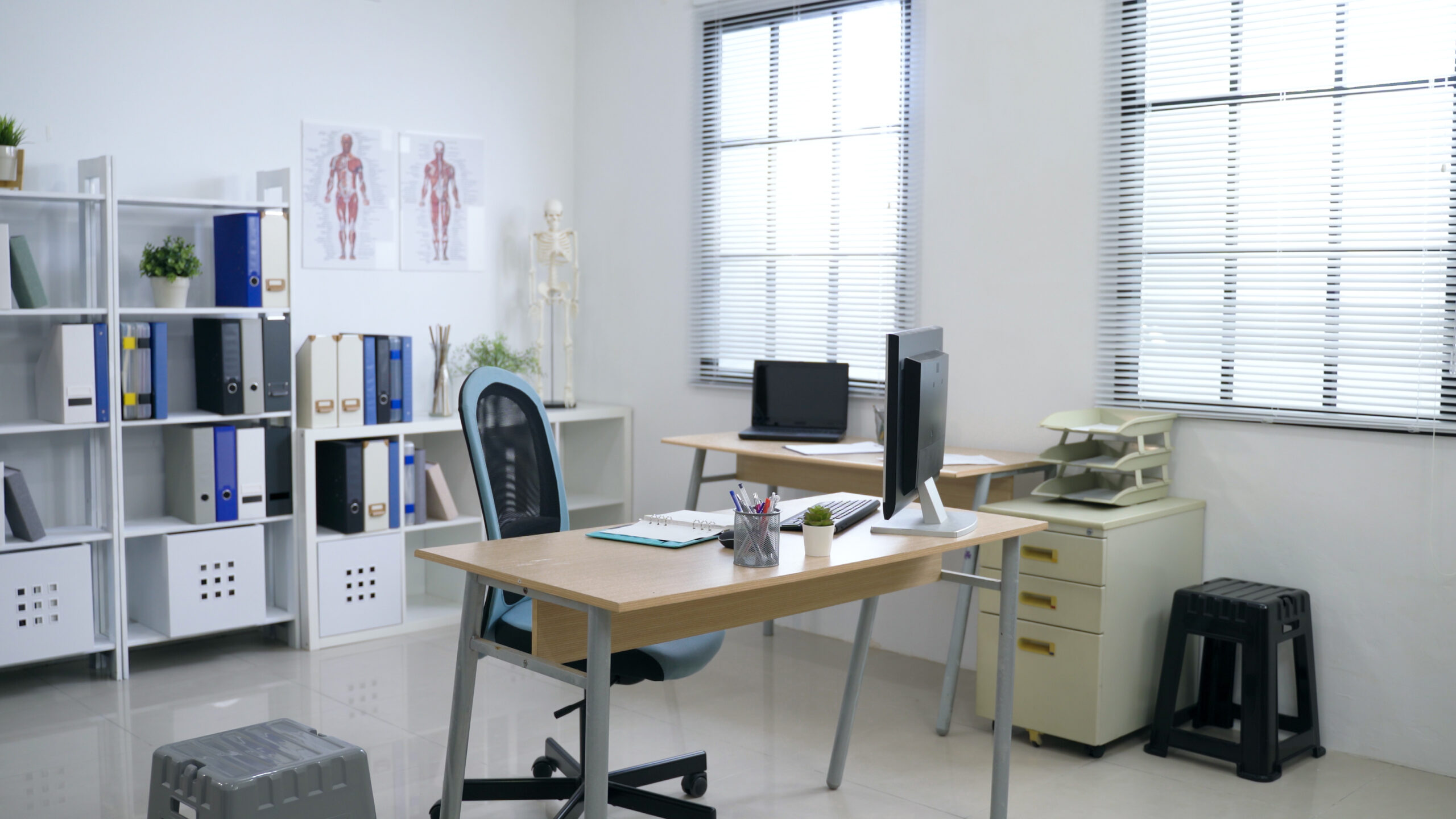 panoramic view of clean and white hospital office with sufficient natural light through louver windows.